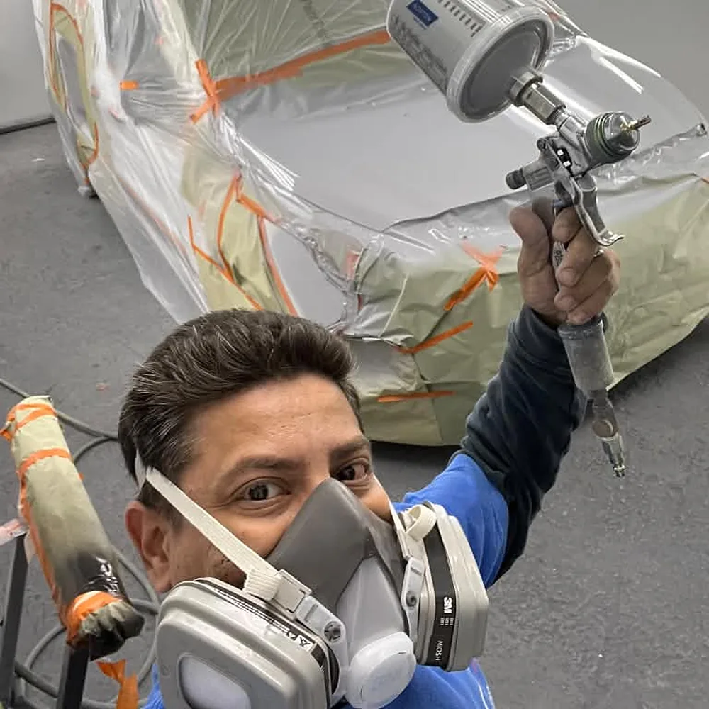 Bryan spraying paint inside the paint booth